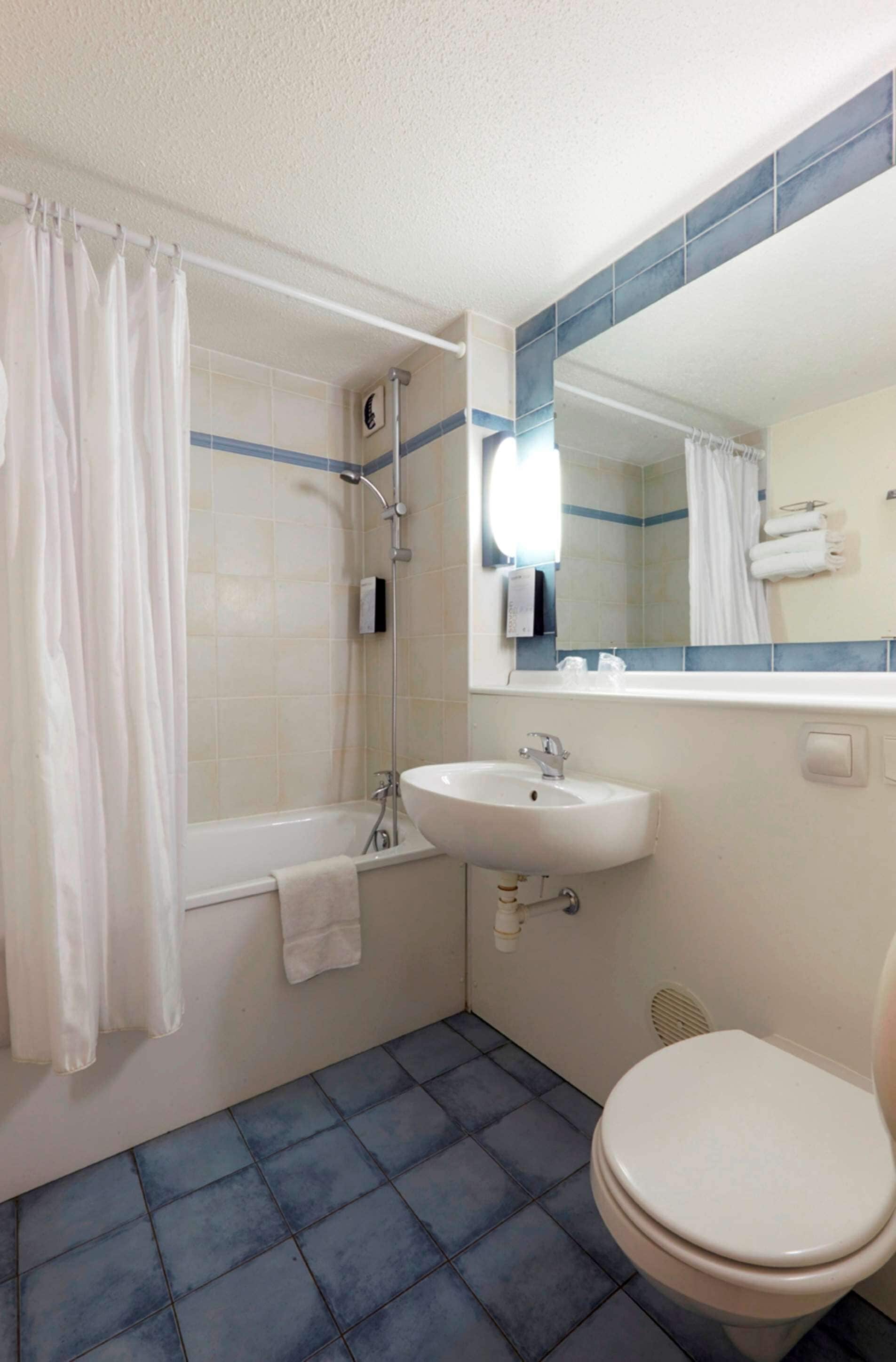 A bathroom with a bathtub, a sink, and a toilet.