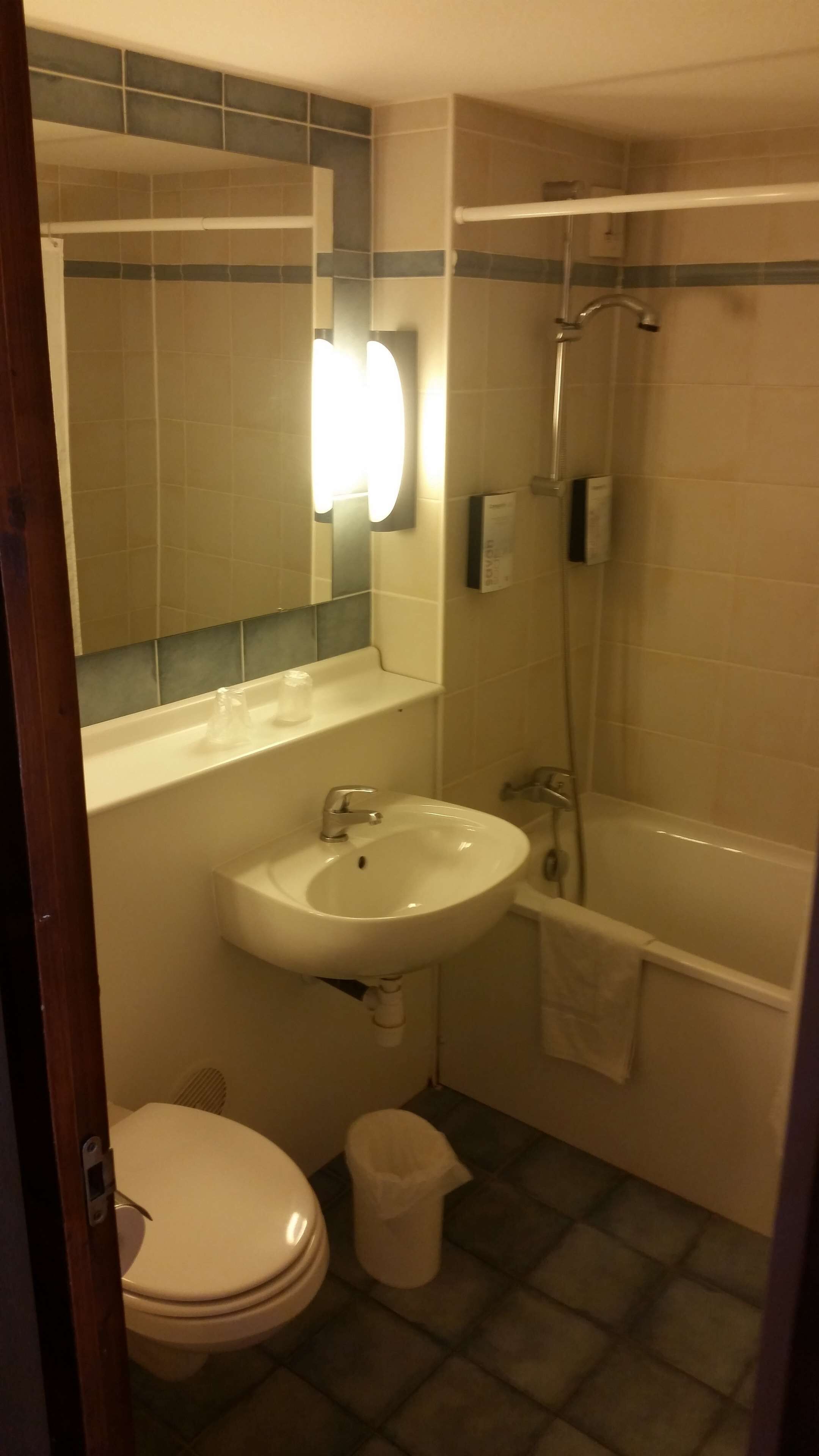 Een badkamer met wastafel, toilet en bad.
