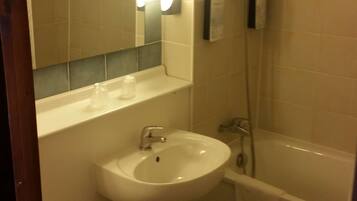 Een badkamer met wastafel, toilet en bad.