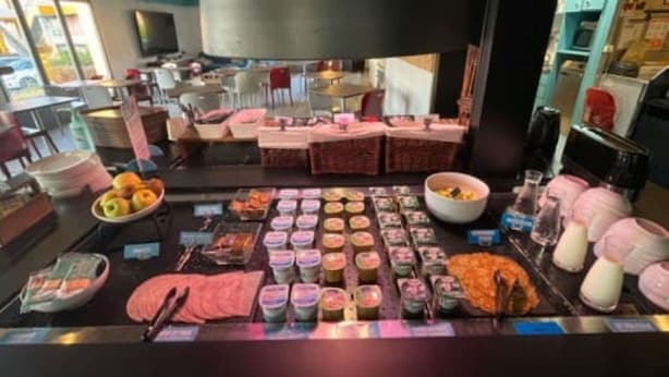 A breakfast buffet with various food items and a coffee station.
