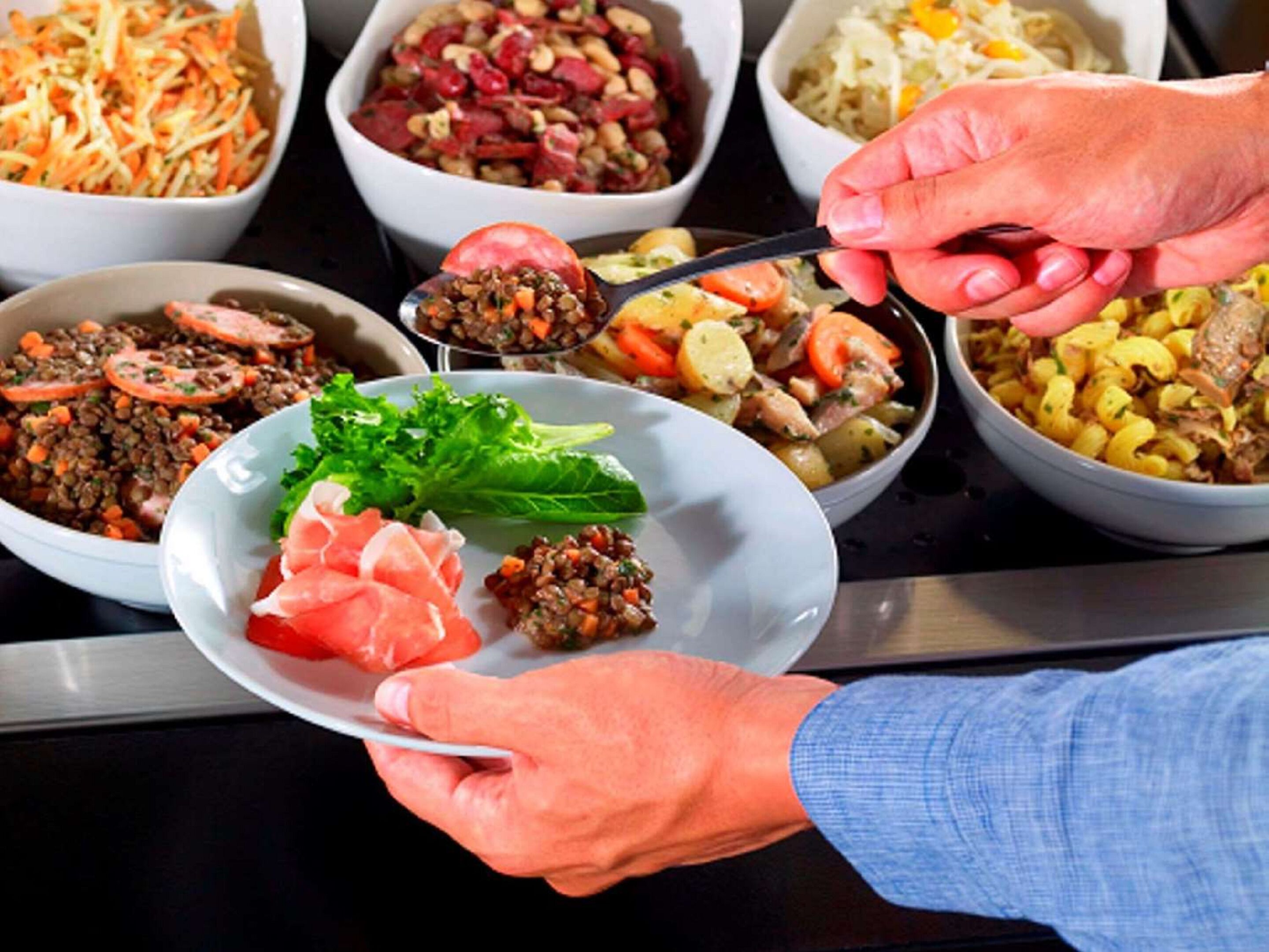 A buffet with various dishes including salads, pasta, and meats.