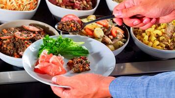 A buffet with various dishes including salads, pasta, and meats.
