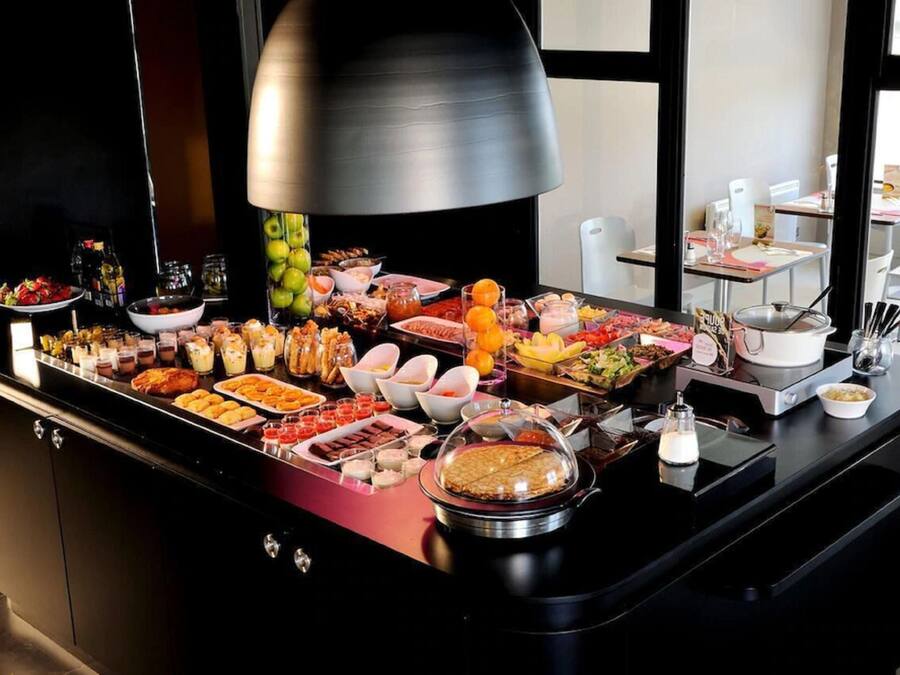 A buffet with various food items and a large overhead light fixture.