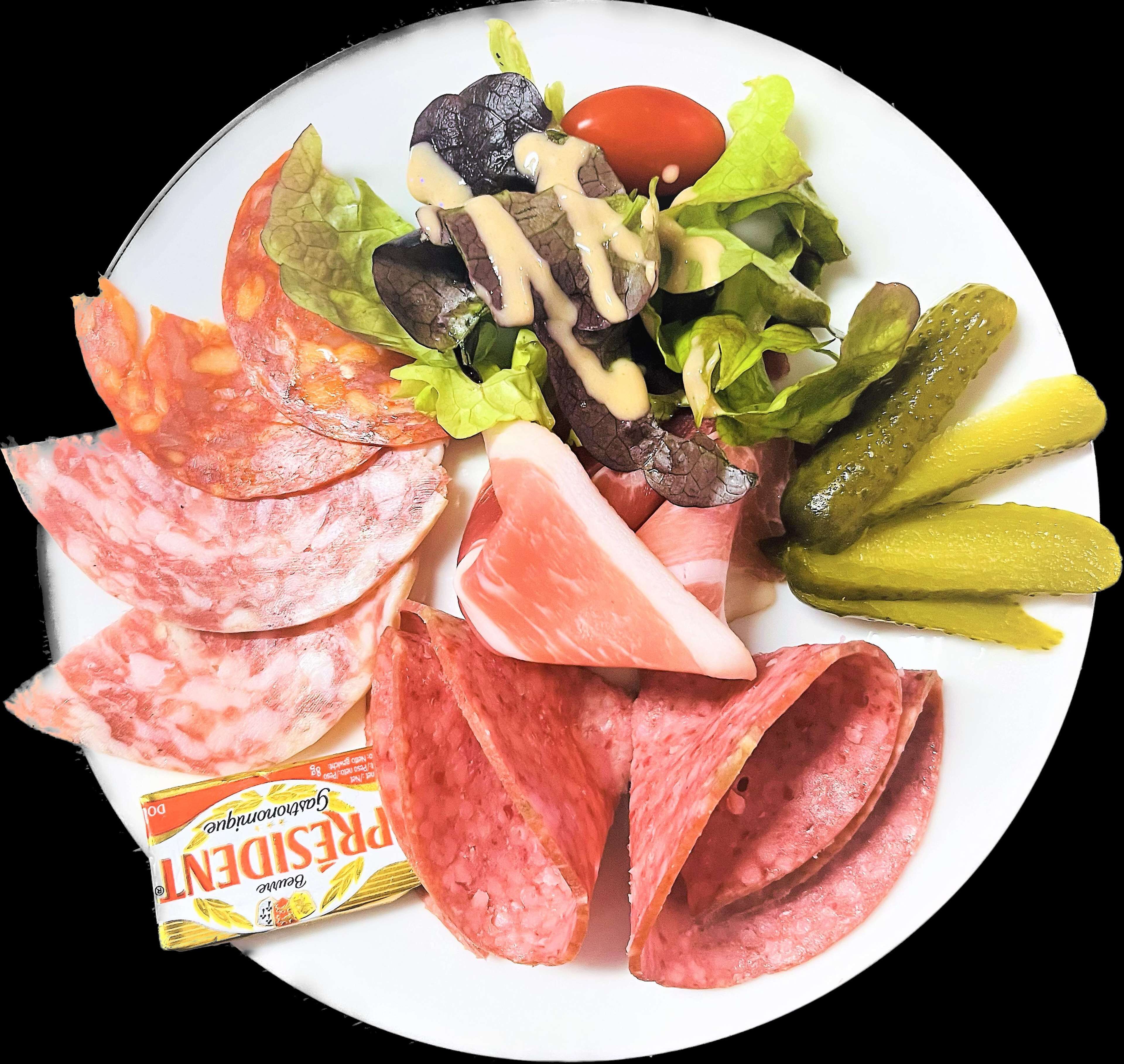 Une assiette garnie de différentes sortes de viandes, de cornichons et d’une salade.