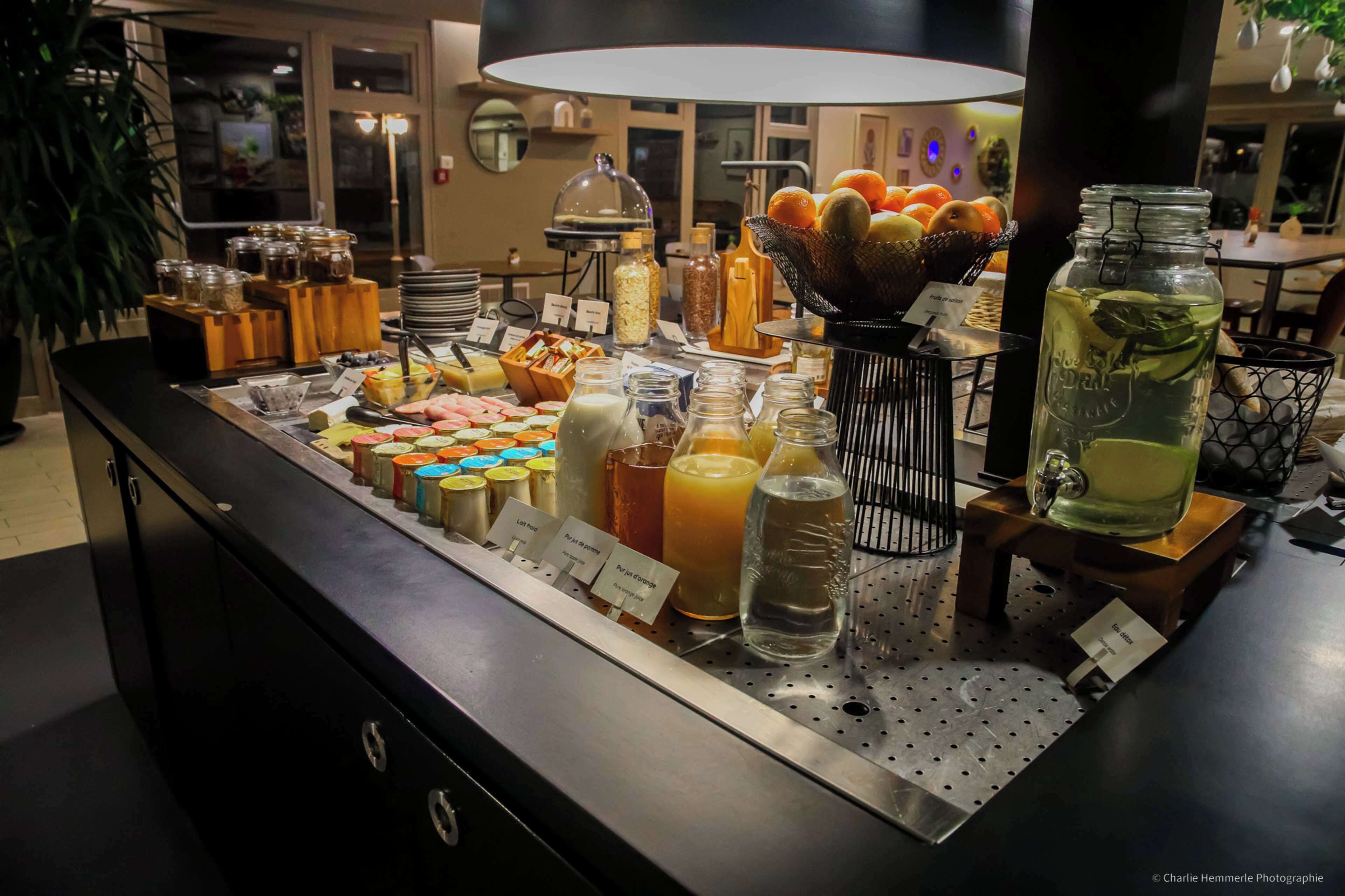 Un buffet proposant une variété de plats et de boissons, notamment des fruits, des fromages et des salades.