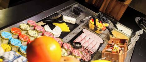 A buffet table with various food items and condiments.