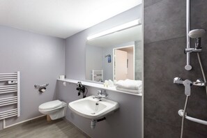 A modern bathroom with a toilet, sink, and shower. - Kyriad Issoudun (Issoudun)