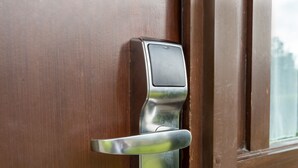 Eine Tür mit einem modernen elektronischen Schloss und einem Metallgriff.