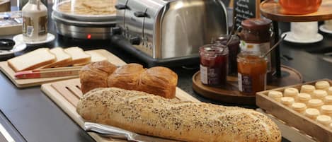 Mostrador de desayuno con pan, bollería y acompañamientos.