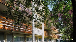 A modern building with multiple balconies, large windows, and a grassy courtyard. - The Originals City, Hôtel La Verrière – Yvelines (La Verriere)