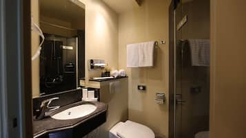 A modern bathroom with a sink, toilet, and shower.