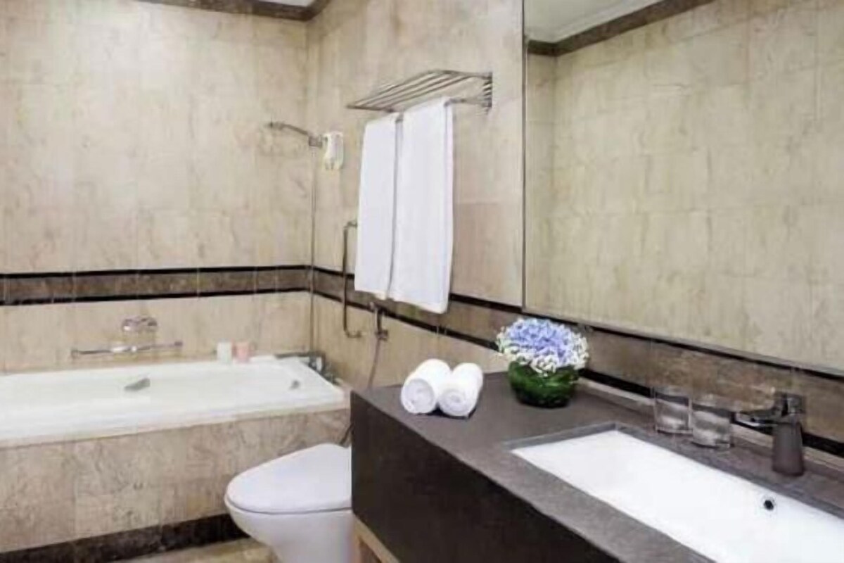Une salle de bain avec une baignoire, des toilettes et un lavabo avec un miroir.
