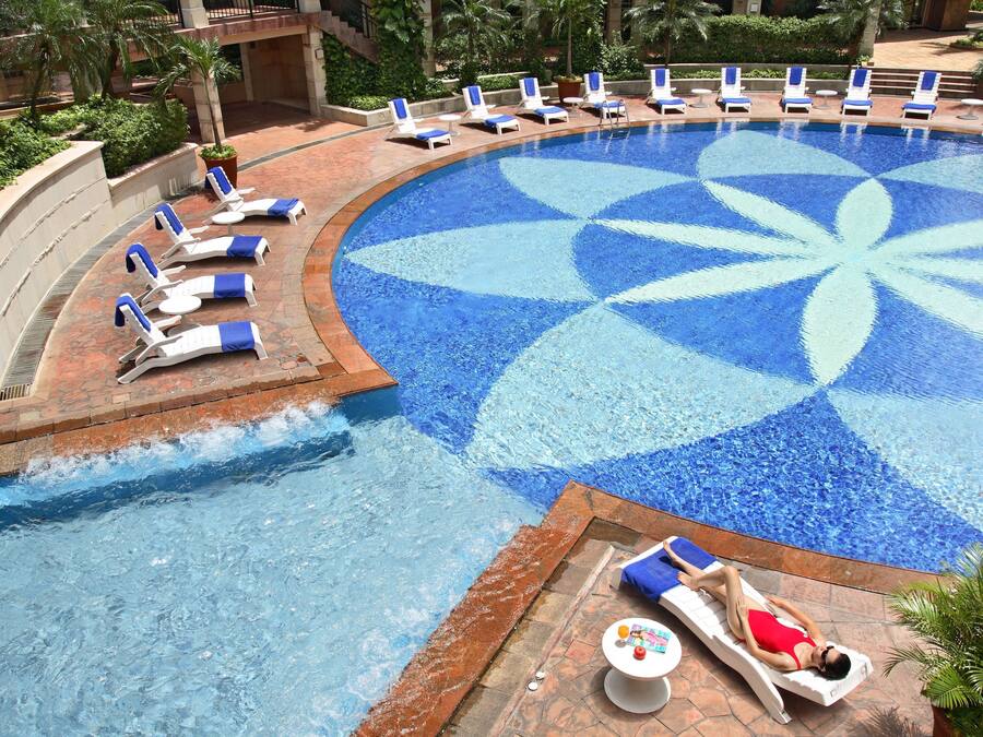 Una piscina al aire libre, sillones reclinables de piscina