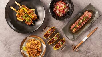 A variety of dishes including skewers, sashimi, and fried calamari.