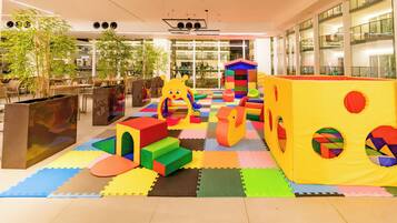 A play area with colorful foam blocks and a yellow playhouse.
