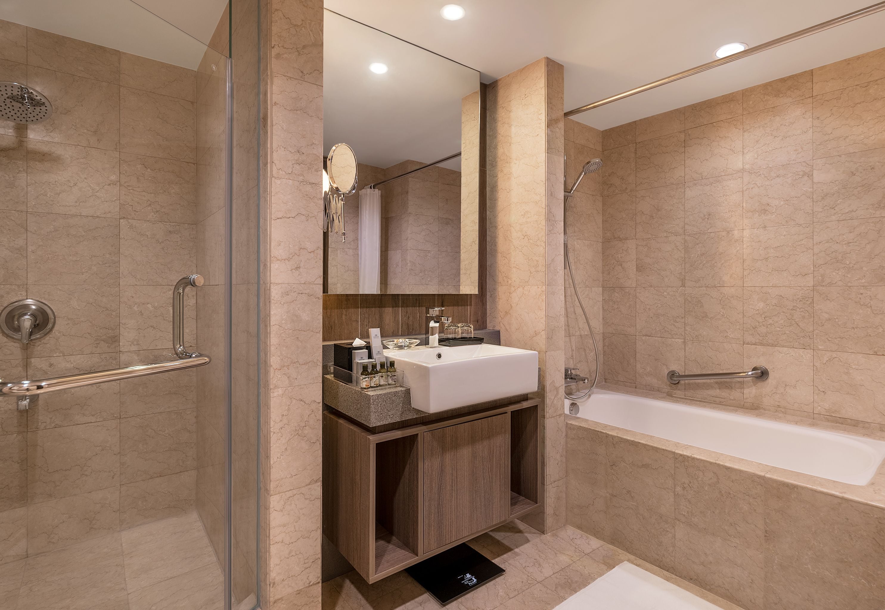 A modern bathroom with a glass-enclosed shower, a vanity with a sink, and a bathtub.