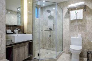Enjoy a refreshing shower in the sleek bathroom with a glass-enclosed shower, standalone toilet, and spacious vanity.