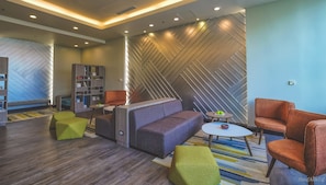 Relax in a stylish lounge area with a comfortable sofa, armchairs, and a bookshelf.