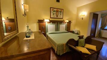 Habitació d'hotel amb un llit de fusta, una nitzeta, un mirall i un quadre a la paret.