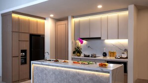 A modern kitchen with a marble countertop, built-in appliances, and wooden cabinetry. - Ascott Jakarta (Jakarta)