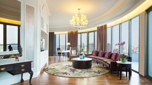A spacious living room with a large window, a chandelier, a sofa, and a coffee table. - Ascott Jakarta (Jakarta)