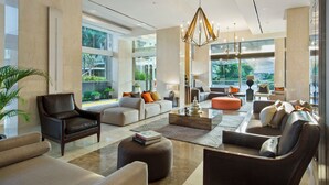 A spacious living area with a modern chandelier, leather sofas, and a coffee table. - Somerset Berlian Jakarta (Jakarta)
