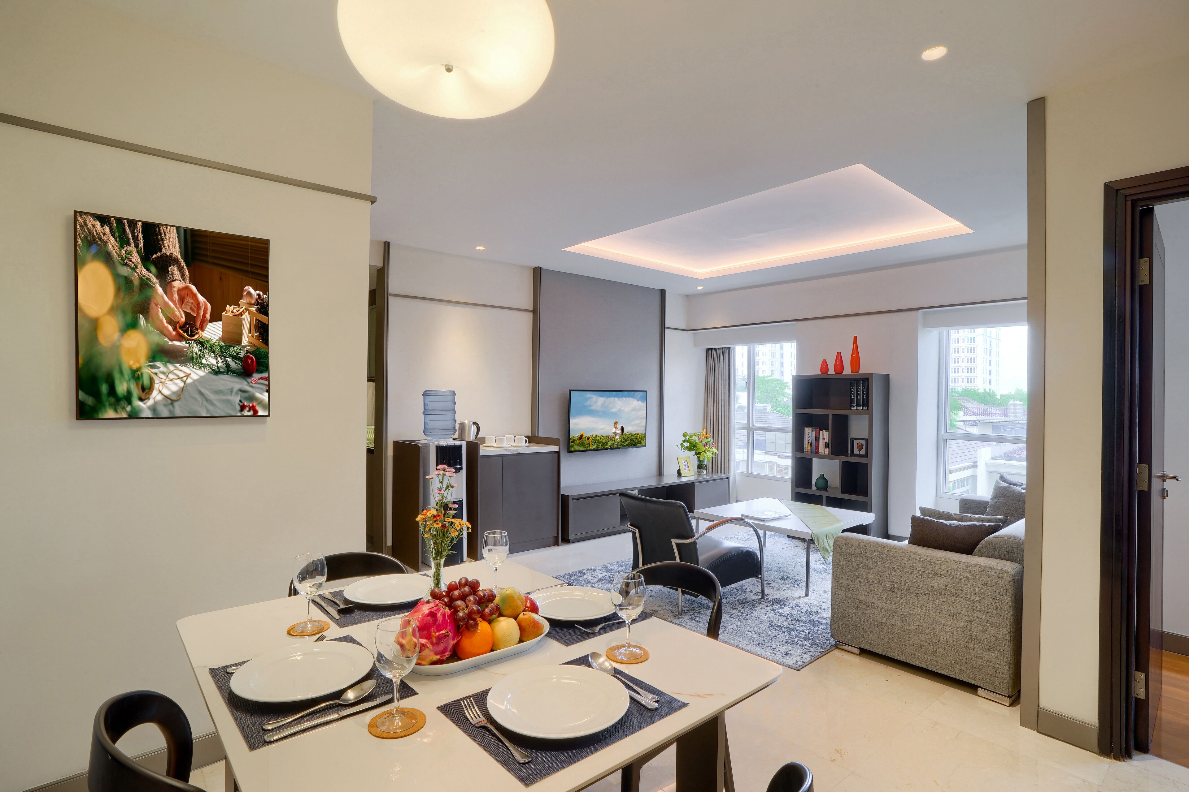 Una moderna camera d'albergo con zona pranzo, angolo salotto e vista sulla città.