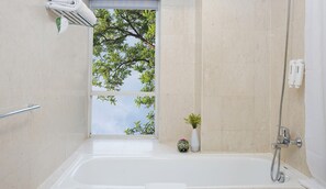 Een bad/douchecombinatie, een diep bad,  milieuvriendelijk toiletgerief