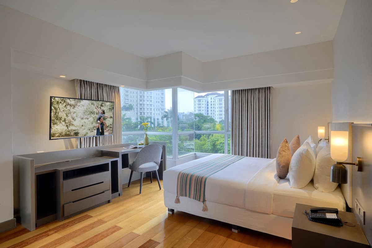 Een moderne hotelkamer met een groot bed, een bureau, een stoel en een televisie.