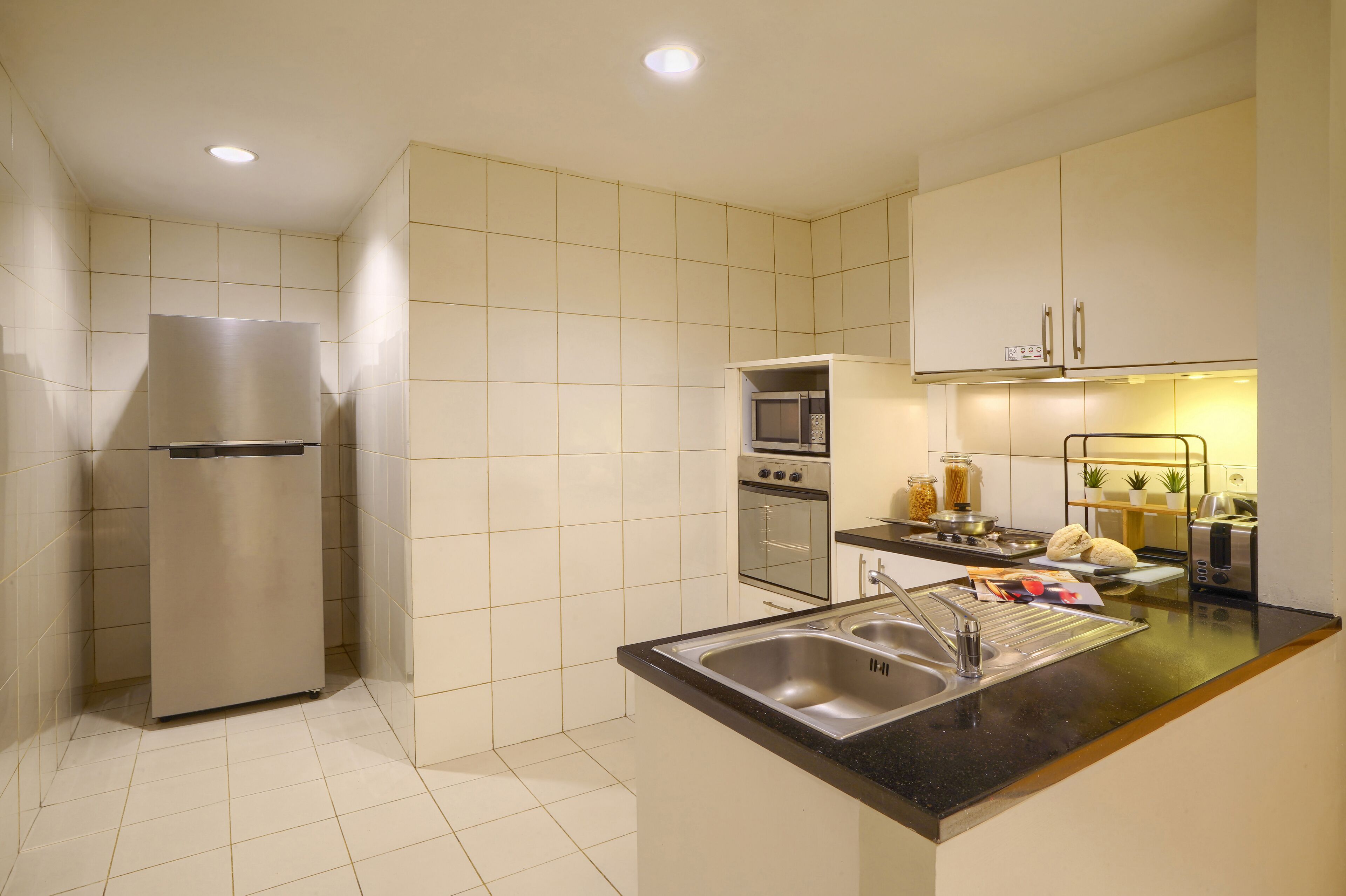 A modern kitchen with a refrigerator, oven, microwave, and sink.