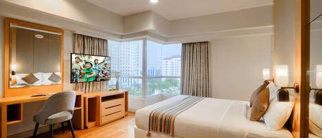 A hotel room with a bed, a desk, a chair, a TV, and a large window with curtains.