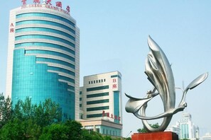 A modern building with a curved facade and signage indicating it is a hotel. - Jincheng Grand Hotel (Jincheng)
