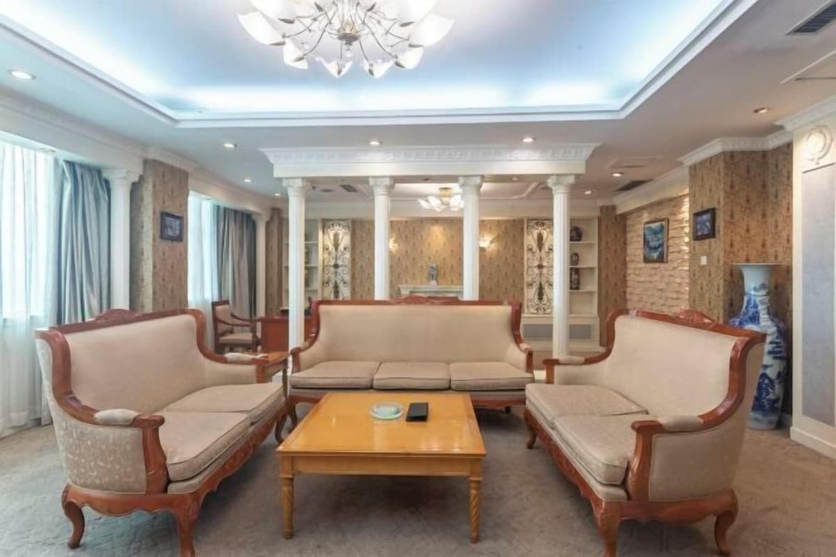 A spacious living room with a high ceiling, a central coffee table, and two sofas.