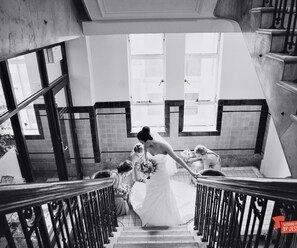 A staircase with a metal railing, a tiled wall, and a window in the background. - Macarthur Chambers (Brisbane)