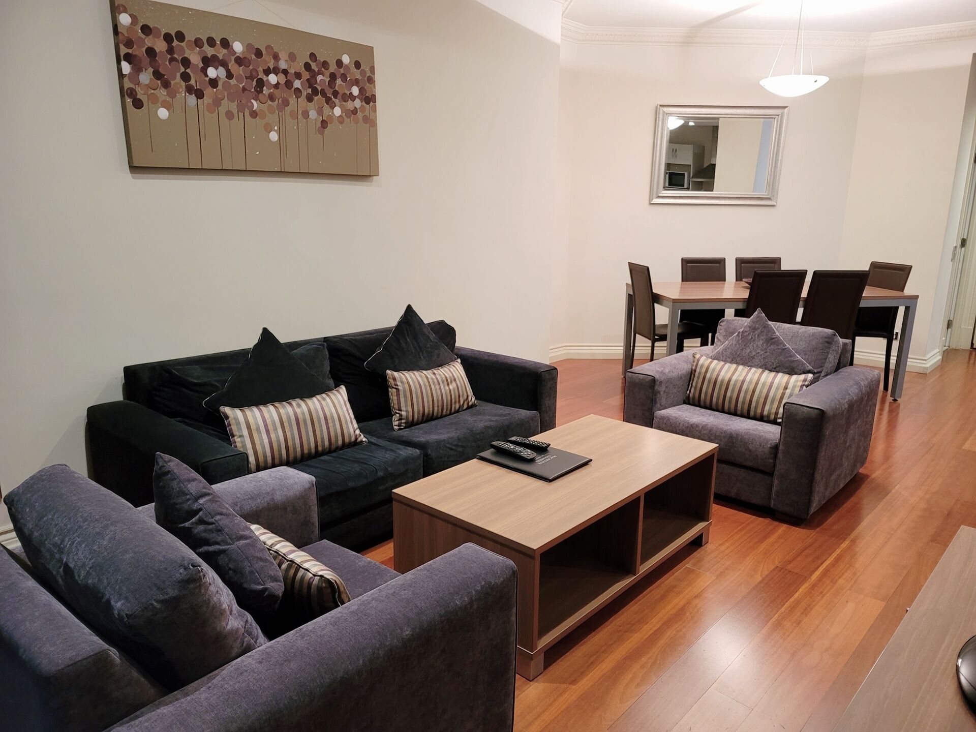 Un salon moderne comprenant deux canapés, une table basse et un coin repas avec une table et des chaises.