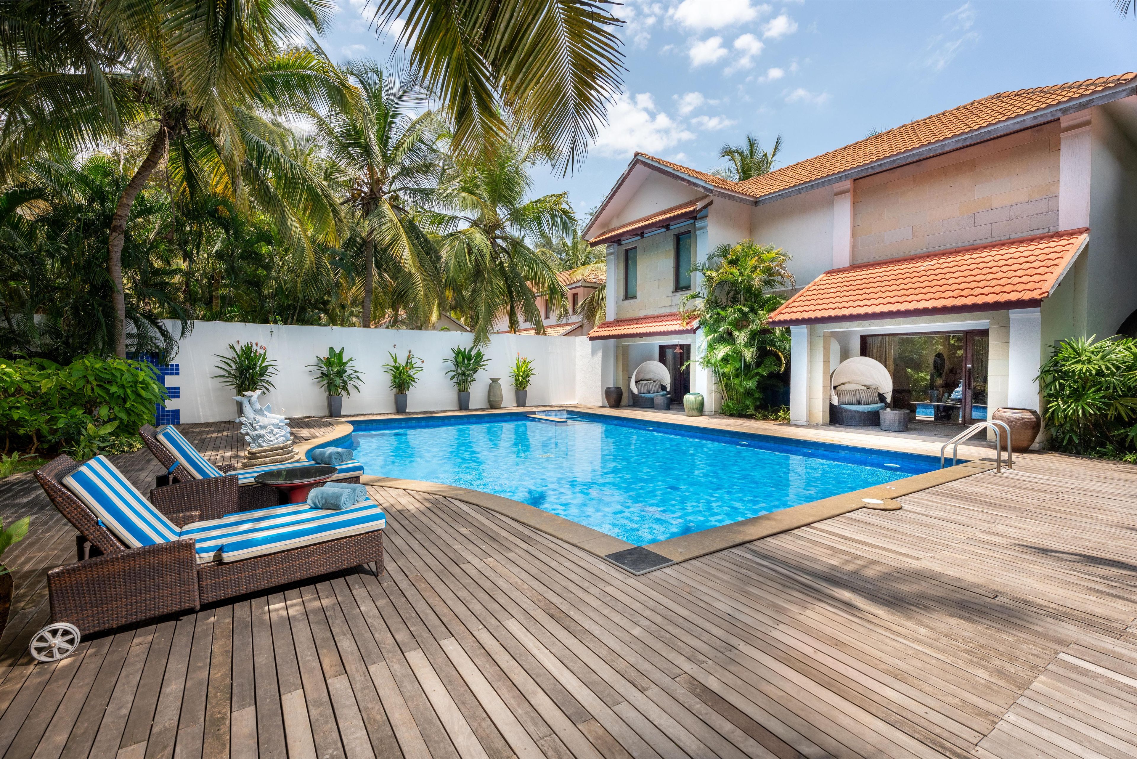 A swimming pool with lounge chairs and a wooden deck.