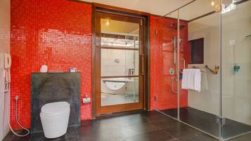 A modern bathroom with a glass-enclosed shower, a white toilet, and a sink with a mirror.