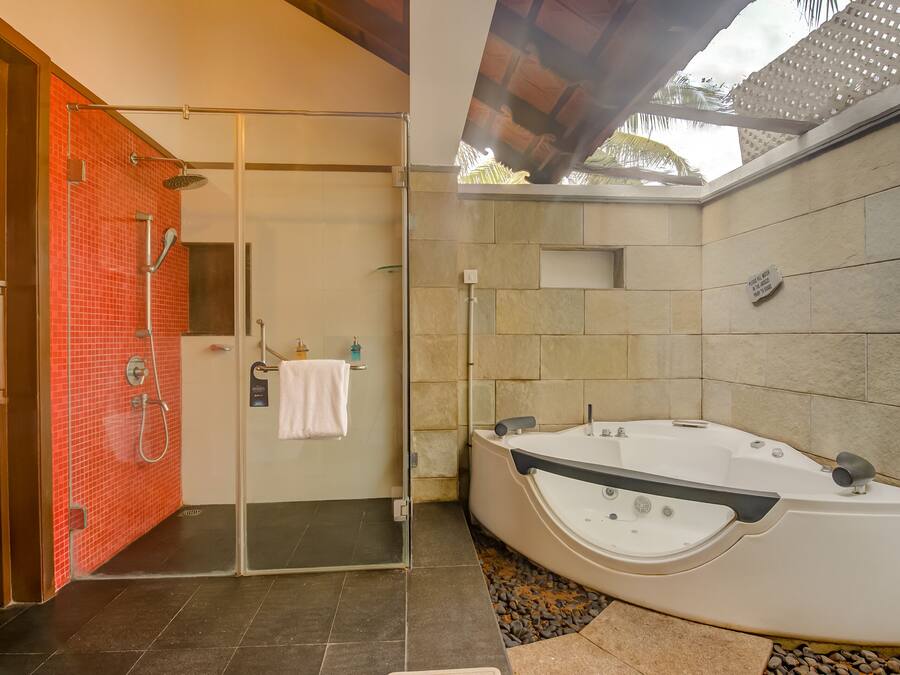 A modern bathroom with a glass-enclosed shower, a large freestanding bathtub, and a tiled floor.