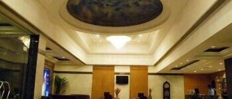 Una hall con una reception centrale, un grande lampadario e un moderno design del soffitto.