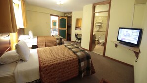 A hotel room with two beds, a television, a desk, and a bathroom visible through an open door. - Hotel De La Villa Hermoza (Cusco)