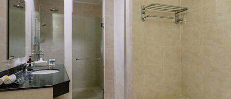 A bathroom with a glass-enclosed shower, a sink with a towel rack, and a bathtub.