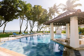 Una piscina al aire libre, sillones reclinables de piscina