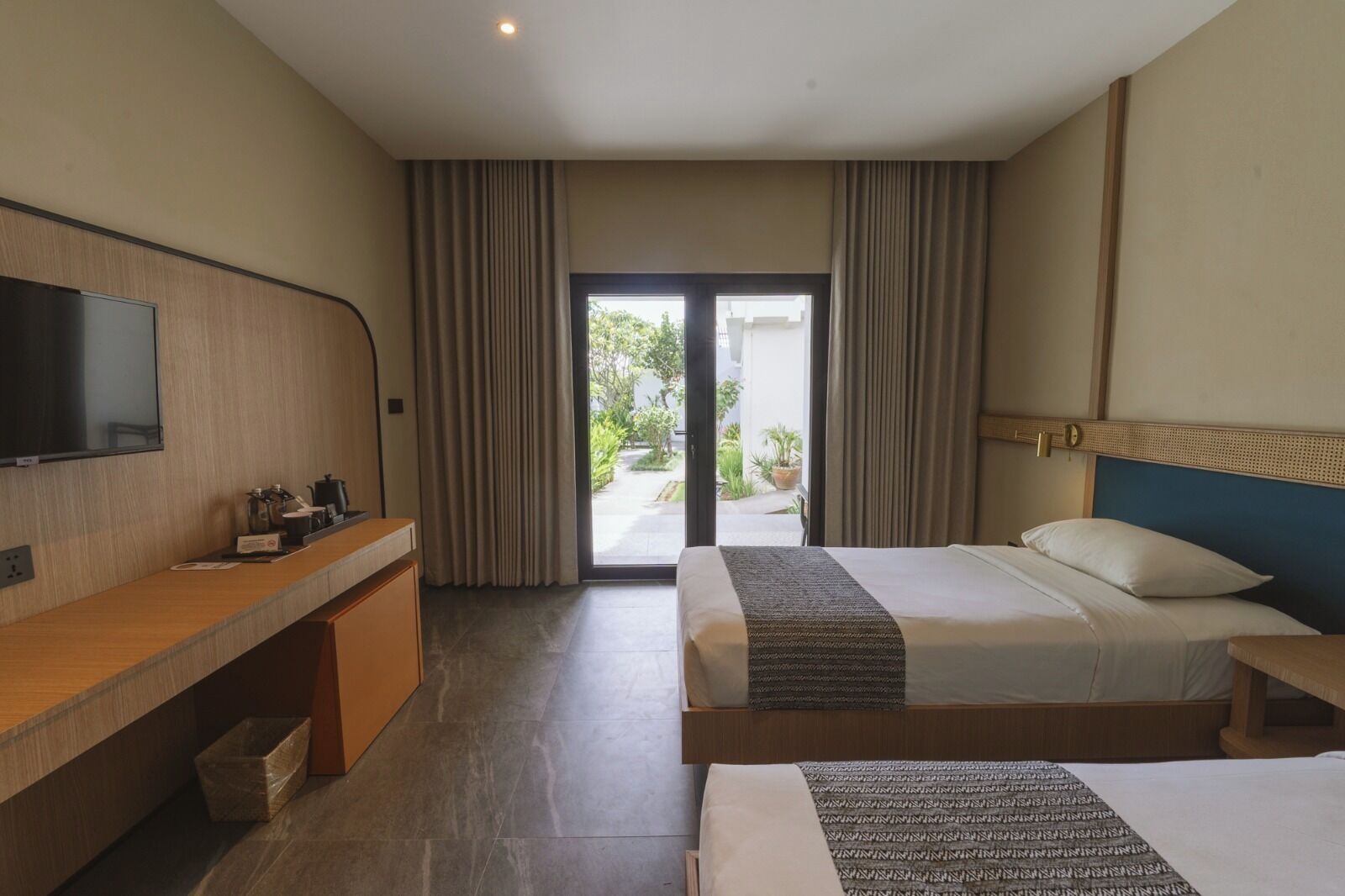 Une chambre d’hôtel équipée d’un lit, d’un bureau, d’une télévision et offrant une vue sur l’extérieur.
