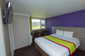 A hotel room with a bed, a desk, chairs, and a television. - Kyriad Chantilly Sud - Luzarches (Chaumontel)