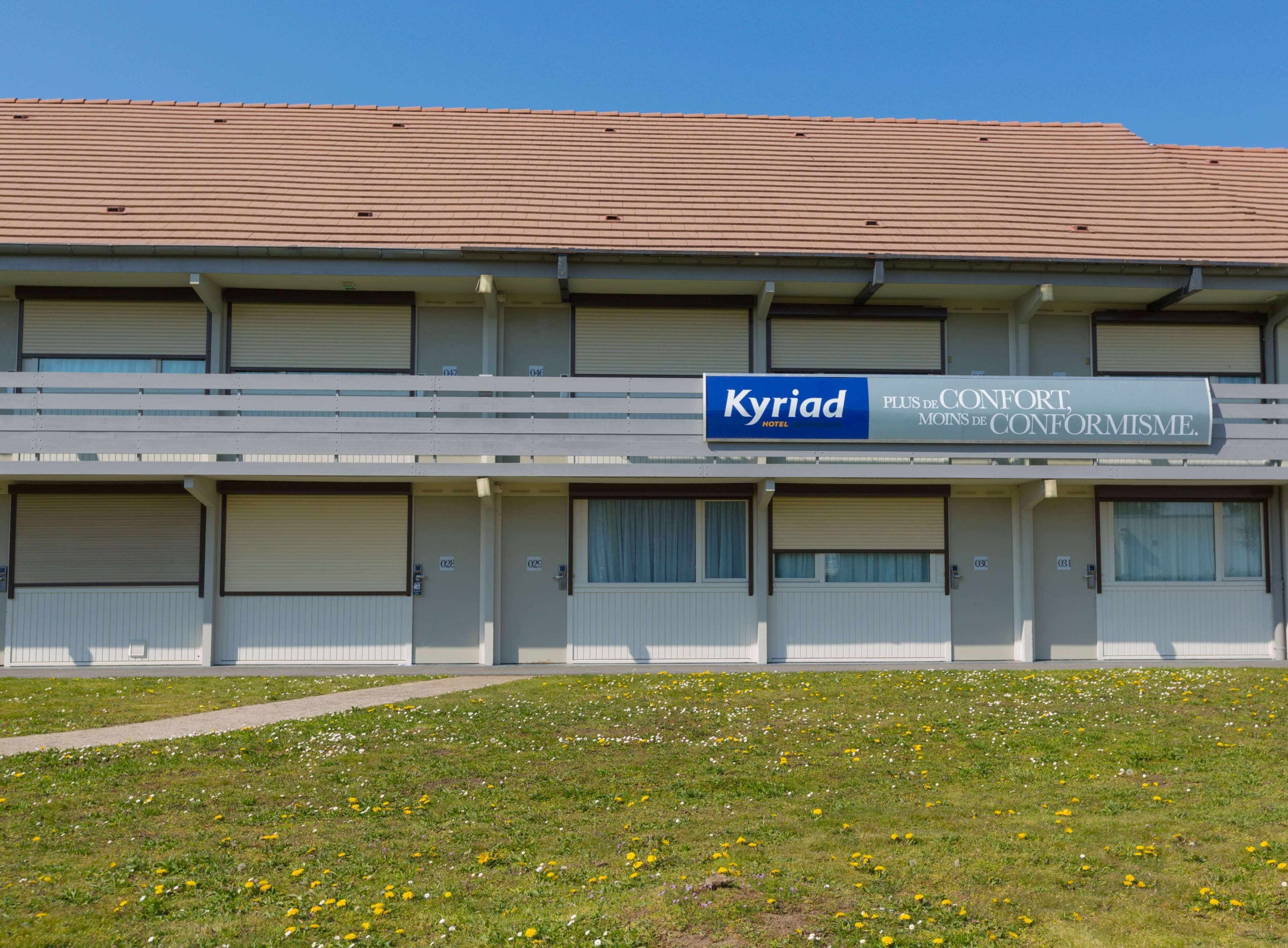 Un bâtiment d'hôtel avec une enseigne indiquant « Kyriad Hotel » et des balcons.