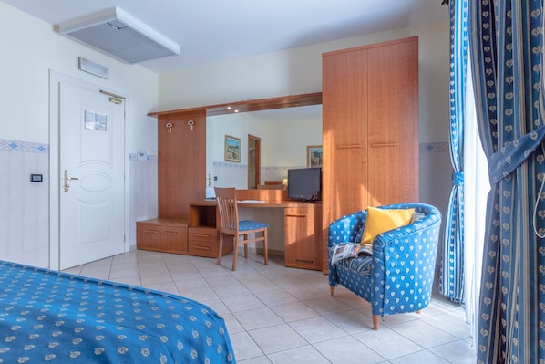 Un dormitorio con cama, escritorio, silla y armario.