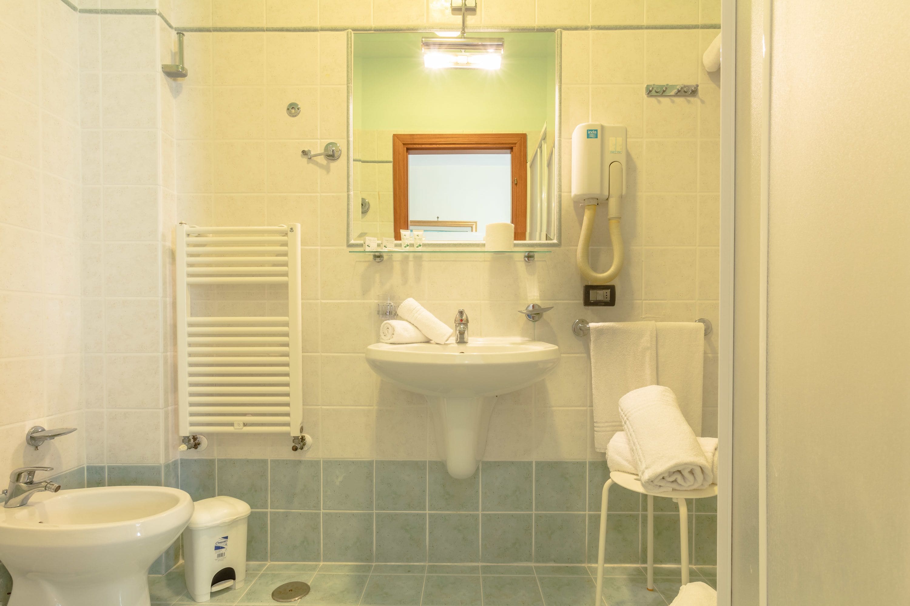 A bathroom with a sink, bidet, and towel rack.