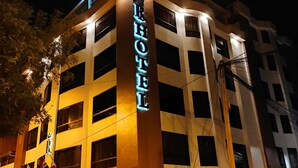 Ein Hotel mit auffälliger Beschilderung, mehreren Etagen und einer gut beleuchteten Fassade bei Nacht.