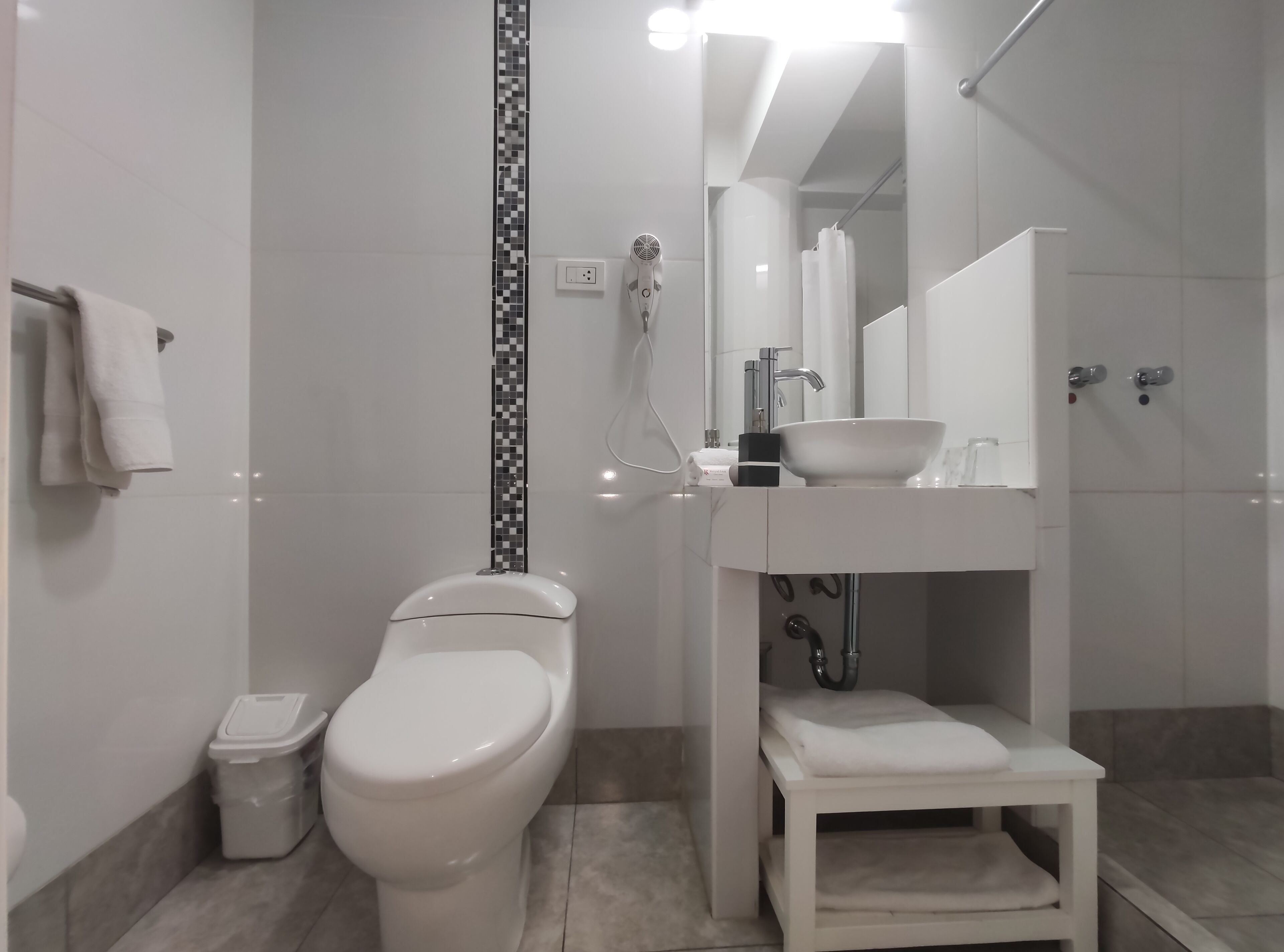 A modern bathroom with a toilet, sink, and shower.