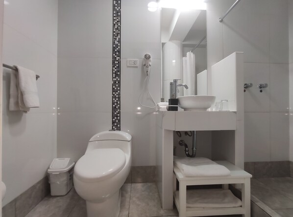 A modern bathroom with a toilet, sink, and shower.